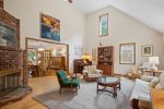 The living room boasts impressive vaulted ceilings and art work